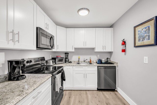 431 SW 1st Ave, Boynton Beach, FL 33435 - kitchen with light hardwood / wood-style floors, appliances with stainless steel finishes, white cabinetry, and sink