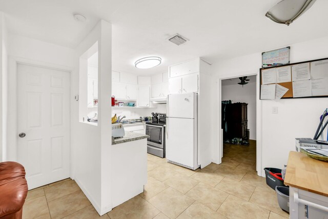 431 SW 1st Ave, Boynton Beach, FL 33435 - kitchen featuring white fridge, light tile patterned floors, sink, stainless steel range with electric stovetop, and white cabinets