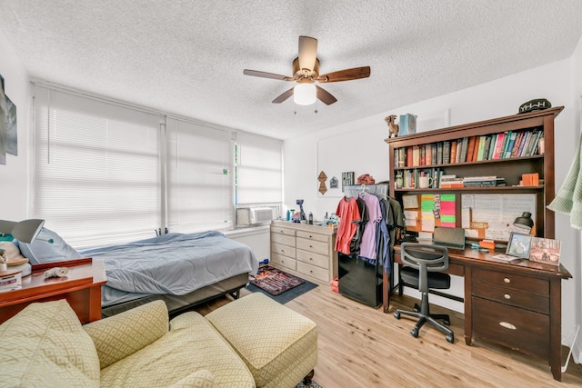431 SW 1st Ave, Boynton Beach, FL 33435 - bedroom featuring cooling unit, light wood-type flooring, ceiling fan, and a textured ceiling