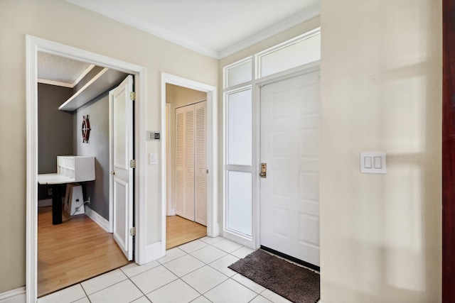 entryway with light tile patterned floors, baseboards, and crown molding