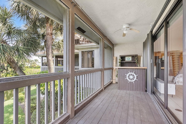 unfurnished sunroom with a ceiling fan