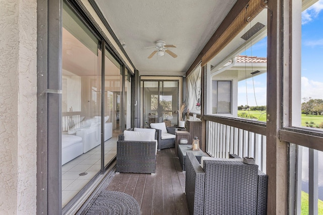 unfurnished sunroom with ceiling fan