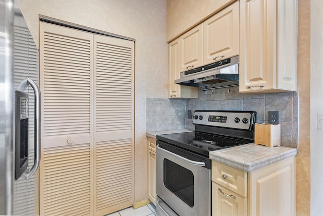 kitchen featuring light tile patterned flooring, under cabinet range hood, stainless steel appliances, light countertops, and tasteful backsplash