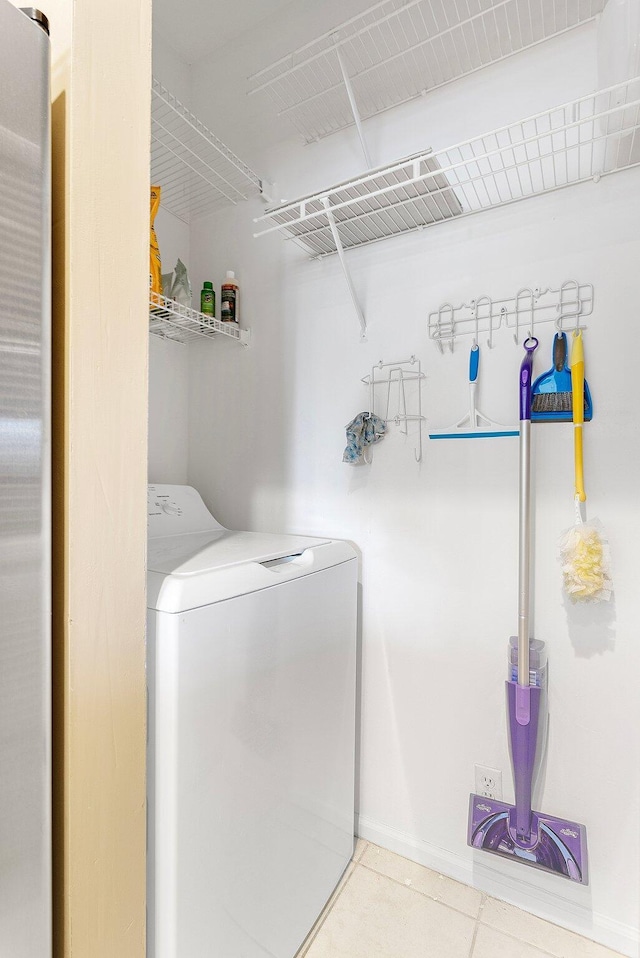 laundry room with baseboards, laundry area, washer / dryer, and tile patterned floors