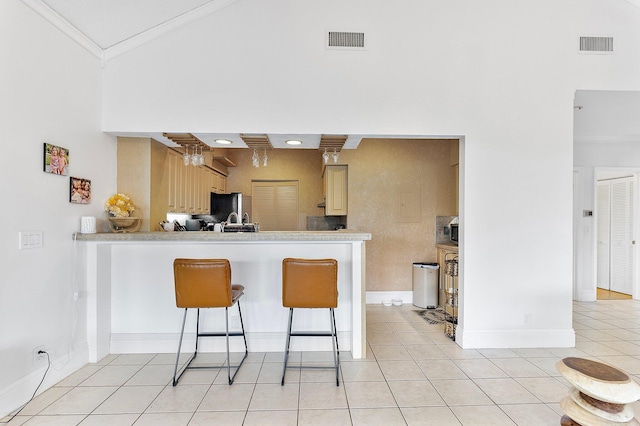 kitchen featuring freestanding refrigerator, light tile patterned flooring, and visible vents