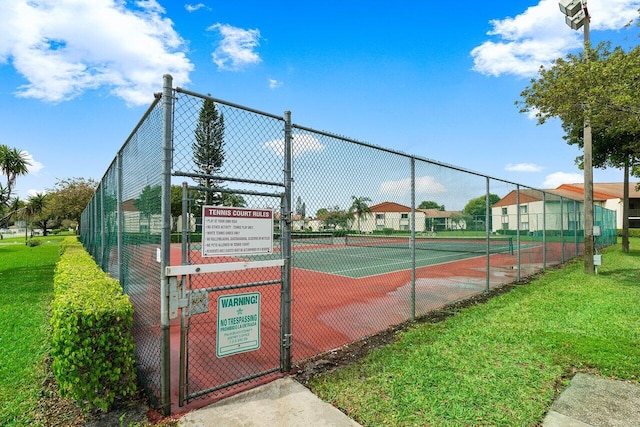 view of tennis court featuring a yard