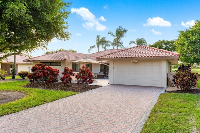 ranch-style home with an attached garage, a tile roof, decorative driveway, and stucco siding