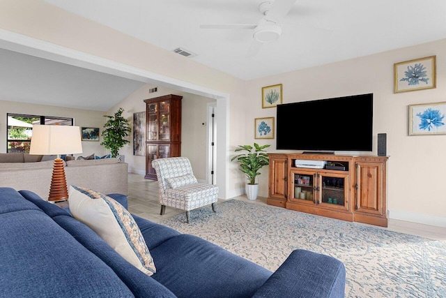 living area with lofted ceiling, baseboards, visible vents, and a ceiling fan