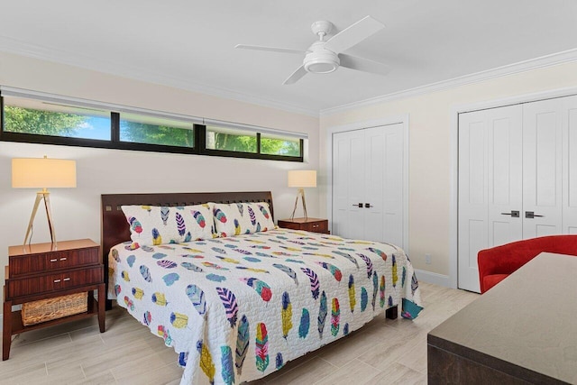 bedroom with ceiling fan, baseboards, ornamental molding, light wood-type flooring, and two closets