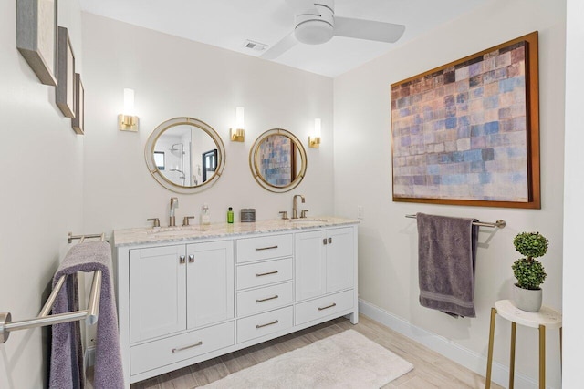 bathroom with a ceiling fan, visible vents, a sink, and wood finished floors