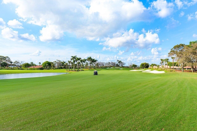 view of property's community featuring golf course view, a water view, and a lawn