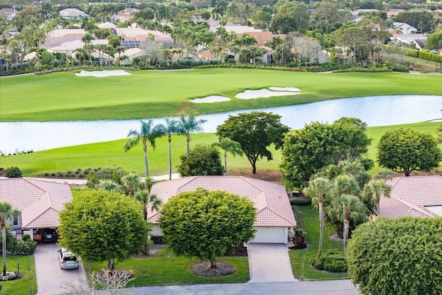 drone / aerial view with view of golf course and a water view