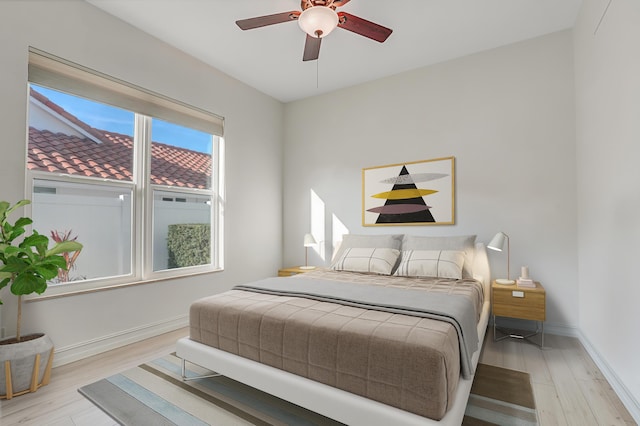 bedroom featuring baseboards, ceiling fan, and wood finished floors