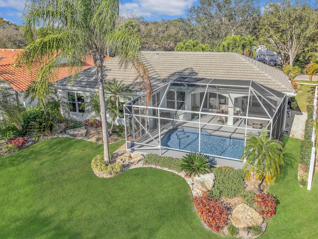 back of property featuring an outdoor pool, a patio area, a tiled roof, a lawn, and glass enclosure