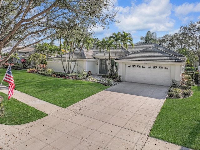 view of front of property featuring an attached garage, driveway, a front yard, and stucco siding