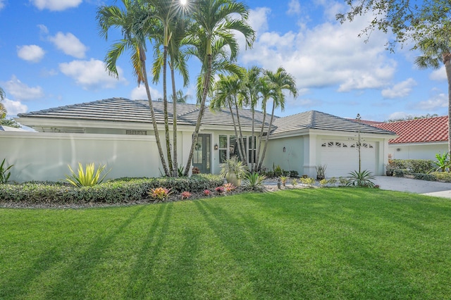 view of front of property with concrete driveway, stucco siding, a front lawn, and a garage