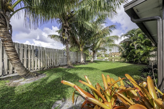 view of yard with a water view and fence