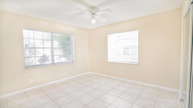 empty room featuring ceiling fan, a textured ceiling, and baseboards