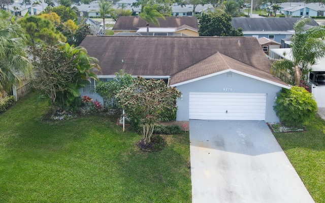 view of front facade with roof with shingles, concrete driveway, a front yard, a garage, and a residential view