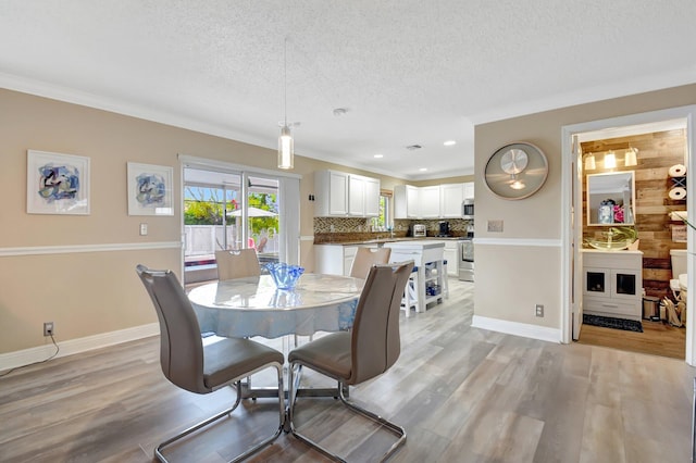 dining area featuring light wood-style floors, baseboards, a textured ceiling, and recessed lighting
