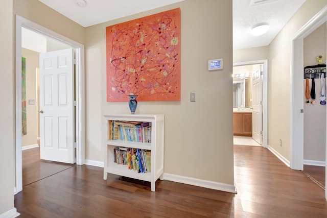 hall with dark wood-style floors and baseboards