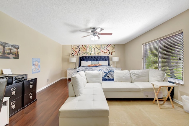 bedroom featuring baseboards, a textured ceiling, and light wood finished floors