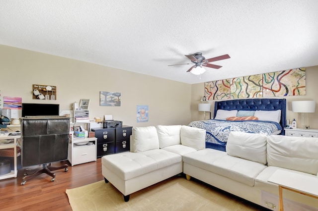 bedroom with a ceiling fan, a textured ceiling, and wood finished floors