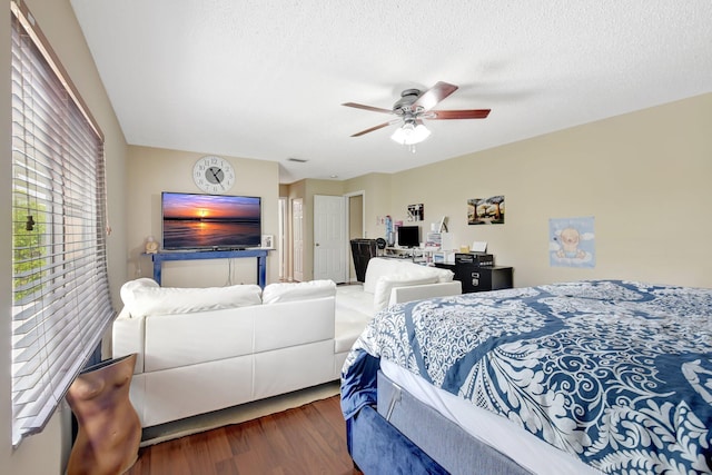 bedroom featuring ceiling fan, a textured ceiling, and wood finished floors