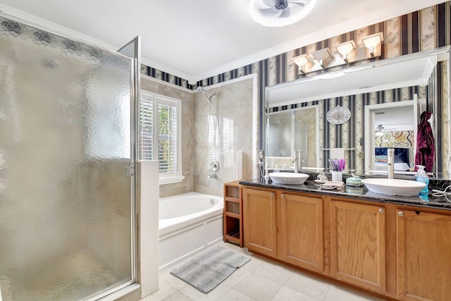 bathroom featuring a stall shower, double vanity, a sink, and a bath