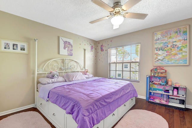 bedroom with a textured ceiling, dark wood-style flooring, and baseboards