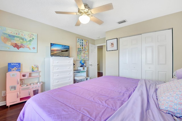 bedroom with a ceiling fan, a closet, visible vents, and dark wood-type flooring