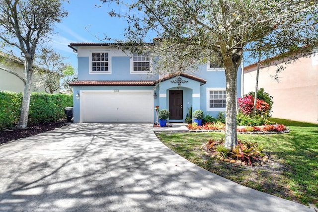 mediterranean / spanish-style house with a garage, a tile roof, concrete driveway, stucco siding, and a front yard
