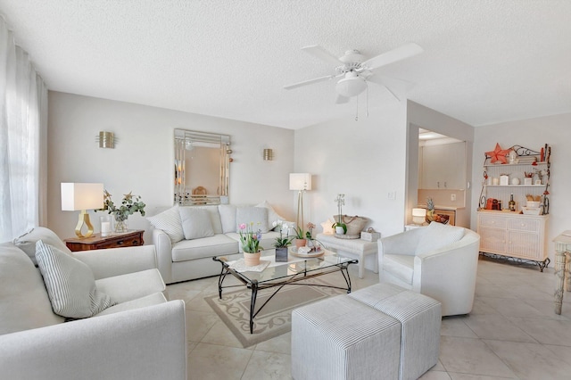 living room with a textured ceiling, light tile patterned flooring, and ceiling fan