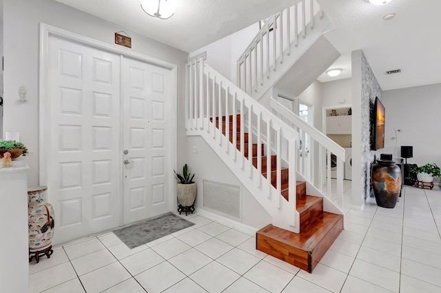 9602 Fox Trot Ln, Boca Raton, FL 33496 - entryway with light tile patterned flooring and a textured ceiling