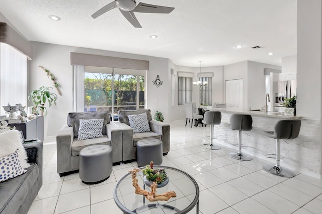 9602 Fox Trot Ln, Boca Raton, FL 33496 - living room featuring ceiling fan with notable chandelier, light tile patterned floors, sink, and a textured ceiling