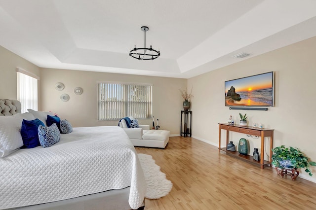 9602 Fox Trot Ln, Boca Raton, FL 33496 - bedroom featuring a tray ceiling, light hardwood / wood-style floors, and a chandelier