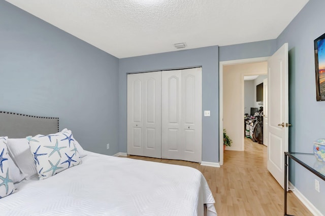 9602 Fox Trot Ln, Boca Raton, FL 33496 - bedroom with light hardwood / wood-style flooring, a closet, and a textured ceiling