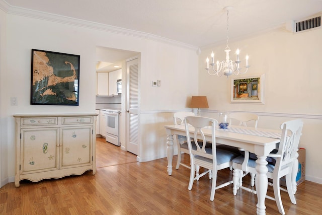 dining space featuring crown molding, baseboards, a chandelier, and light wood-style floors