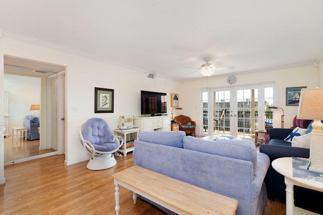 living area featuring french doors, crown molding, light wood-style flooring, and ceiling fan