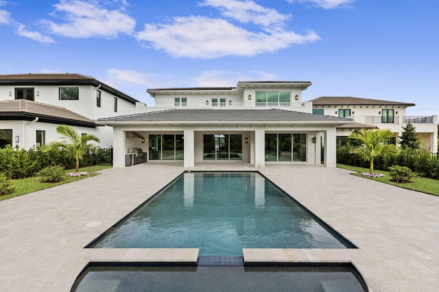 back of property featuring a patio and an outdoor kitchen