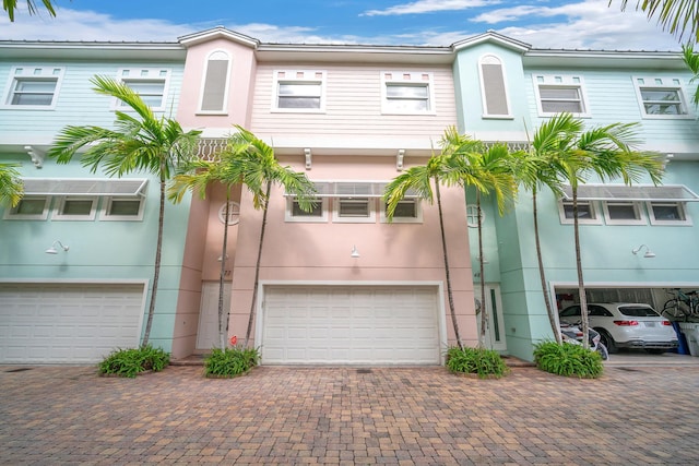 townhome / multi-family property with decorative driveway and stucco siding