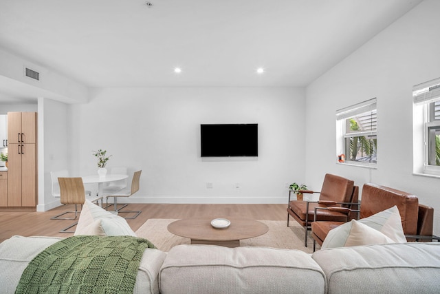 living area with recessed lighting, light wood-type flooring, visible vents, and baseboards