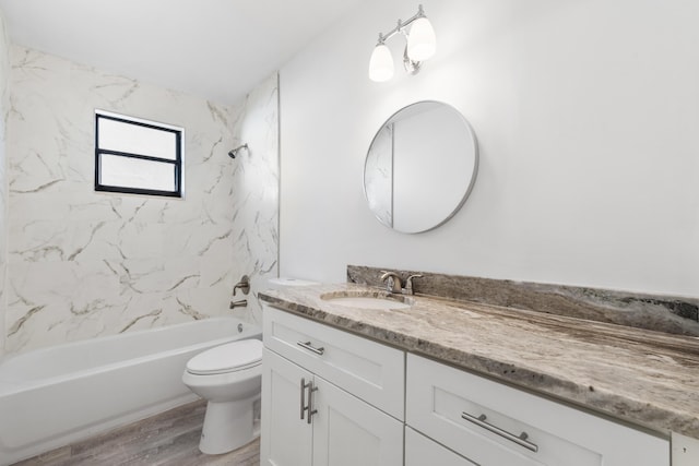 full bathroom featuring toilet, vanity, tiled shower / bath, and wood-type flooring