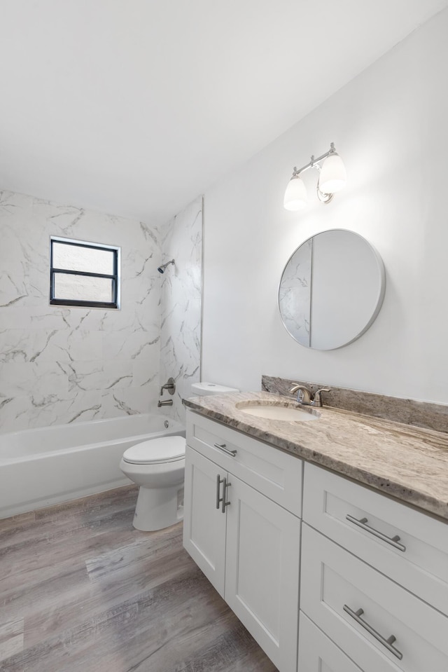 full bathroom featuring hardwood / wood-style flooring, toilet, vanity, and tiled shower / bath