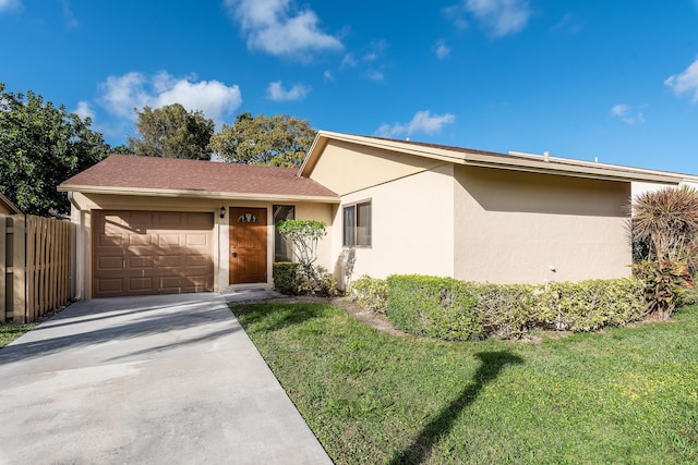 ranch-style house with a garage and a front lawn