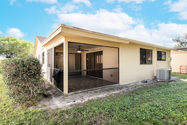 rear view of property featuring cooling unit, a yard, a sunroom, and ceiling fan