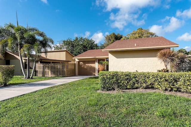 single story home featuring a garage and a front lawn