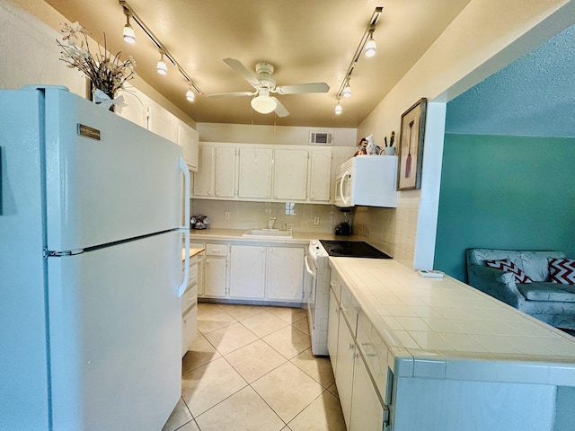 kitchen with visible vents, backsplash, white cabinets, light tile patterned flooring, and white appliances