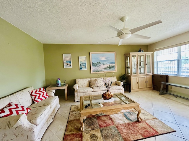 living room featuring light tile patterned floors, a textured ceiling, and a ceiling fan