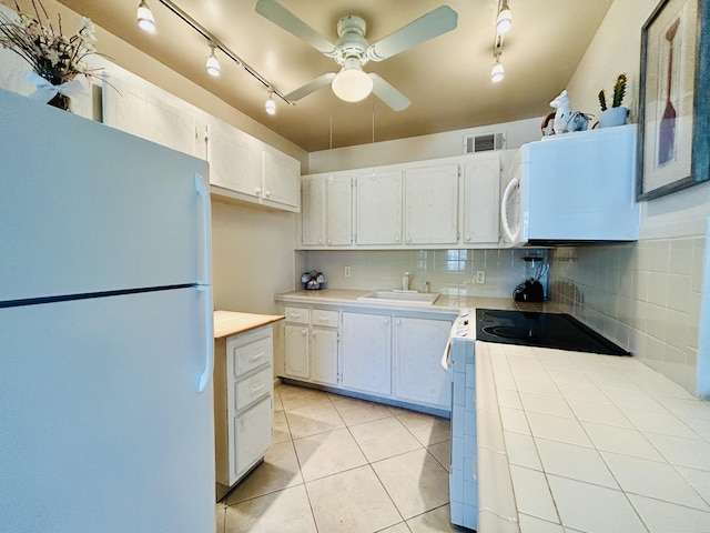 kitchen featuring tasteful backsplash, white cabinets, a sink, light tile patterned flooring, and white appliances